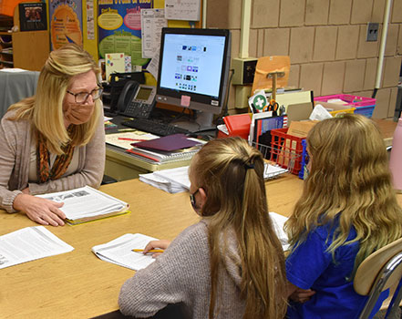 Elementary students with teacher at table