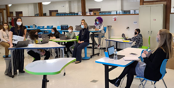 students seated and standing in the makerspace room, conducting a mock trial