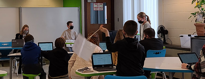 students seated and standing in the makerspace room, conducting a mock trial