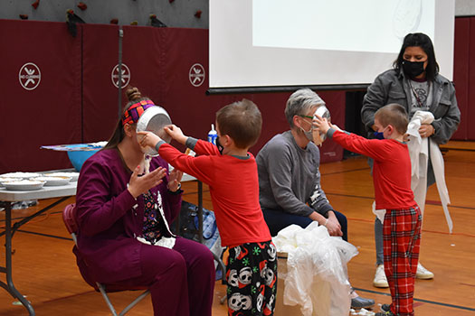 students placing pies on the faces of a teacher and the principal