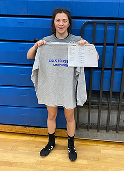 Lexi holding a tournament shirt