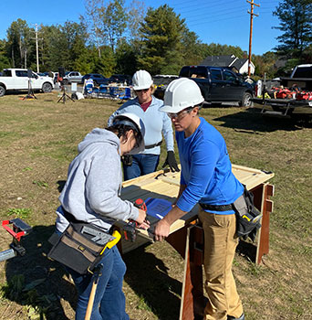 Maddy, Principal and construction pro working with power tools outside