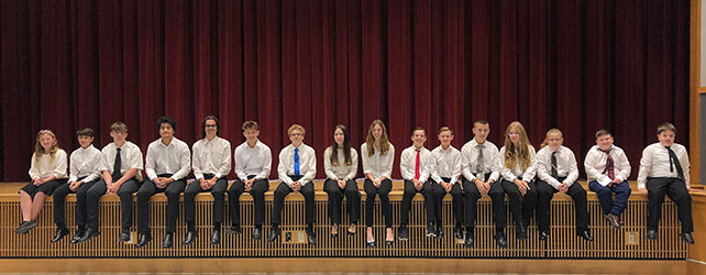 students sitting on edge of stage