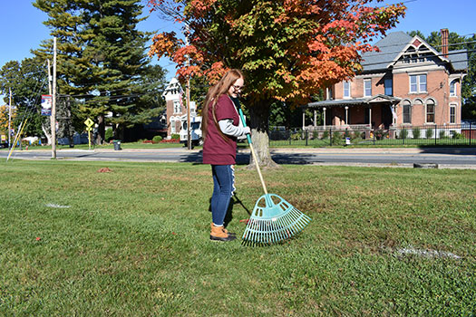student raking lawn