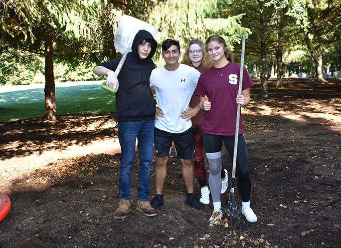 3 students with garden tools