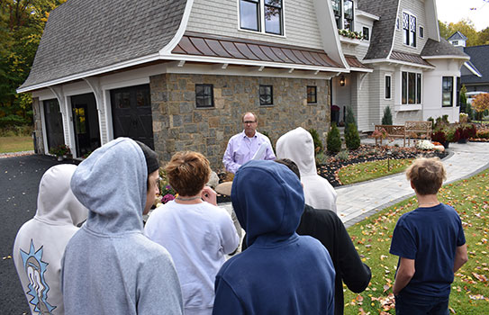 John Witt talking to students outside finished home