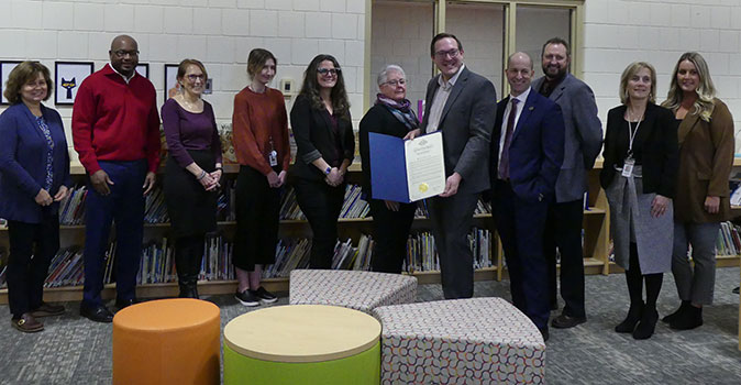 group of educators and officials, with Chris White holding proclamation