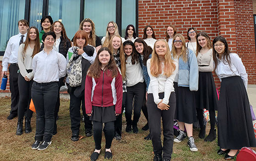 group of students standing in front of school