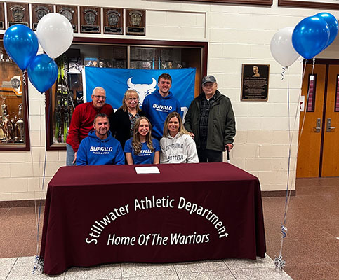 student and family seated at and standing behind table