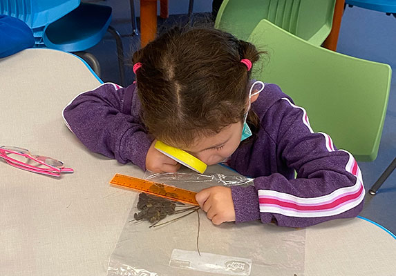 student looking through a magnifying glass