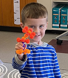 student holding a model he created