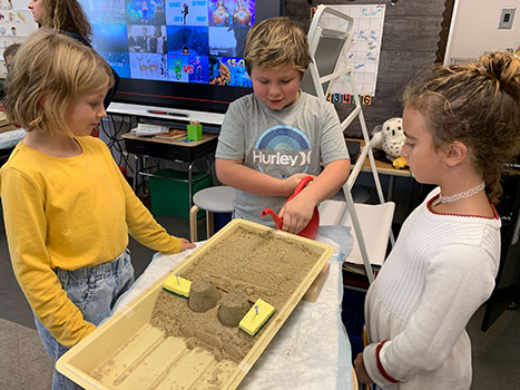 students working with sand tower science kit