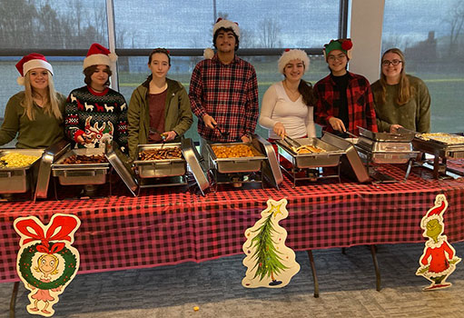 students standing behind food serving table