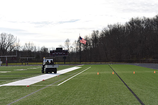 golf cart driving off course on athletic field