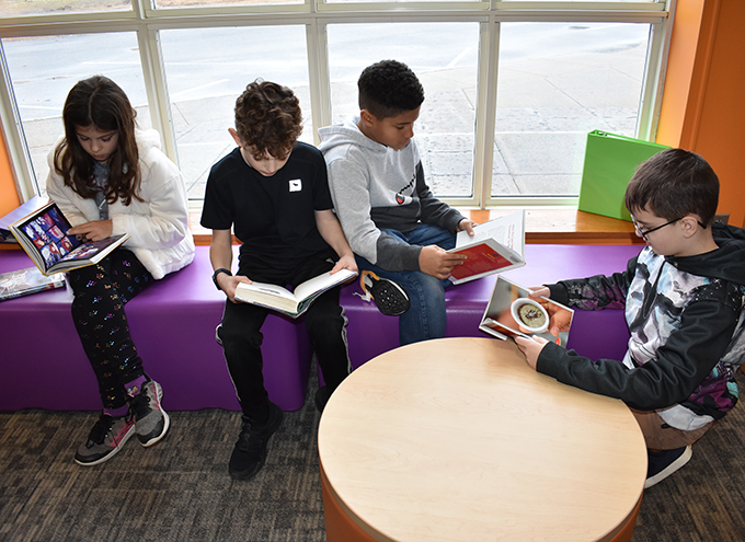 students reading books by library window