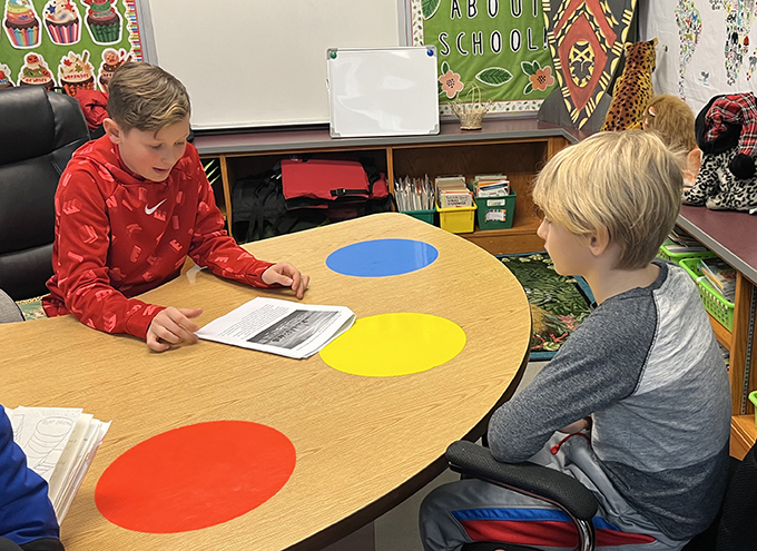 6th grade student reading to 3rd grade student 