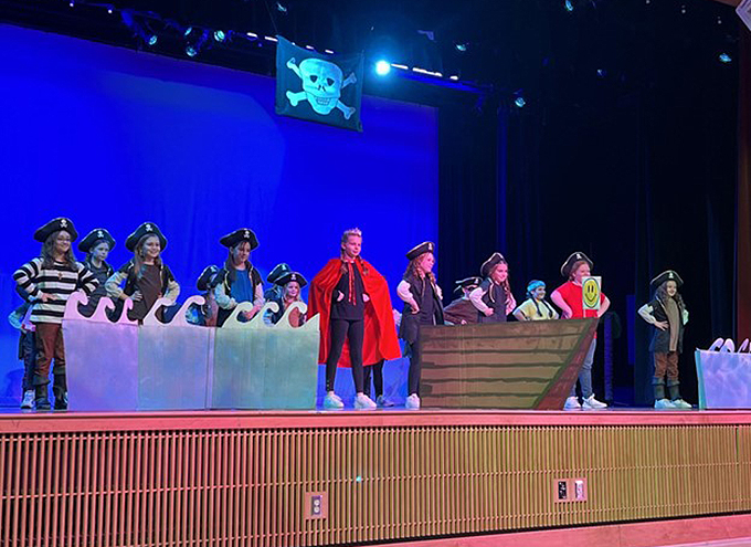 students in costume performing on stage