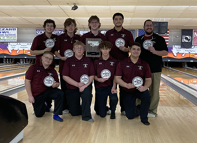 Bowling team holding awards at end of bowling alley