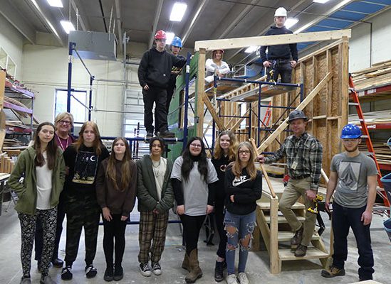 group of students and principal in construction classroom