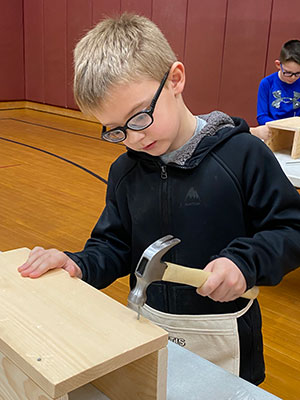 student hammering a toolbox