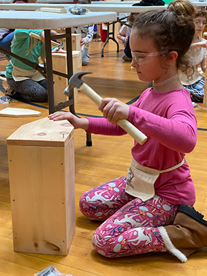 student hammering a toolbox