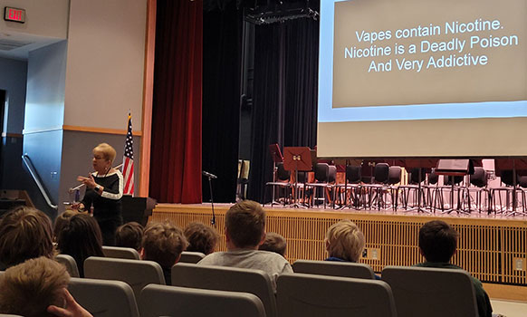 Patty Kilgore talking to students in the auditorium