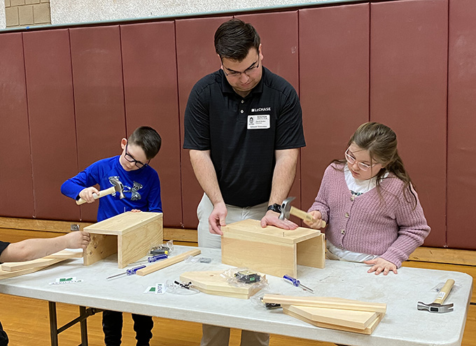 2 students and adult building wooden toolboxes