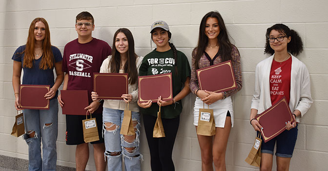 6 students standing in a group holding certificates