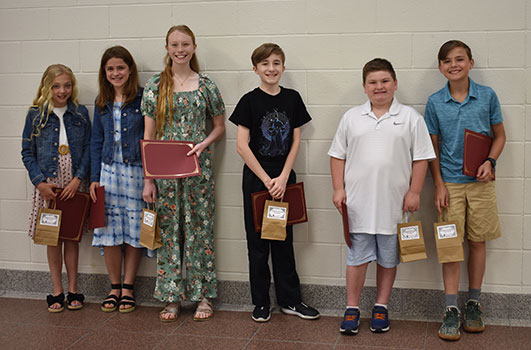 6 students standing in a group holding certificates