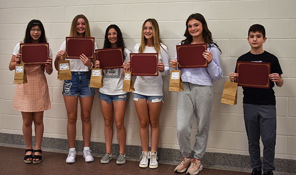 6 students standing in a group holding certificates