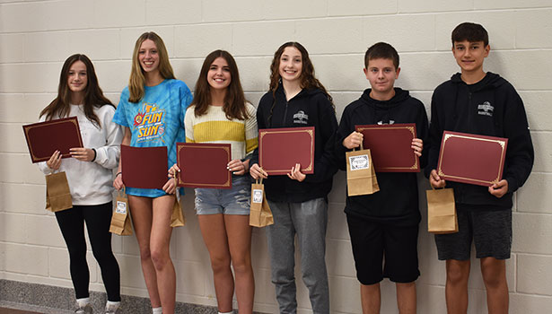 6 students standing in a group holding certificates