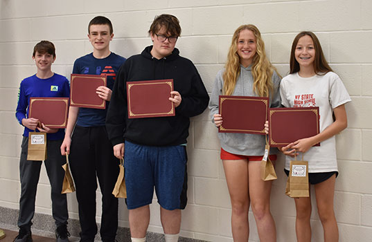 6 students standing in a group holding certificates