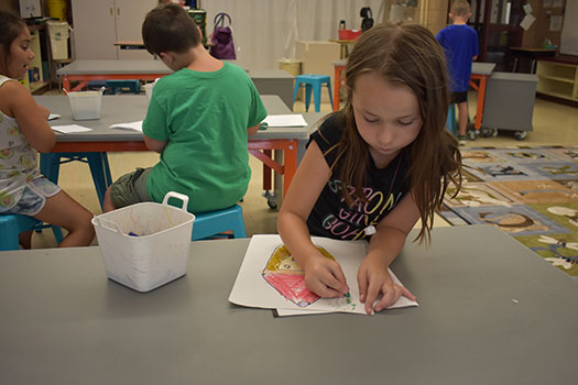 student working on a drawing in art room