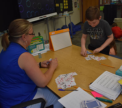 teacher and student using playing cards