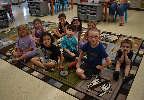 students sitting in a group on a classroom rug