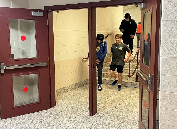 Three students walking in the hallway.
