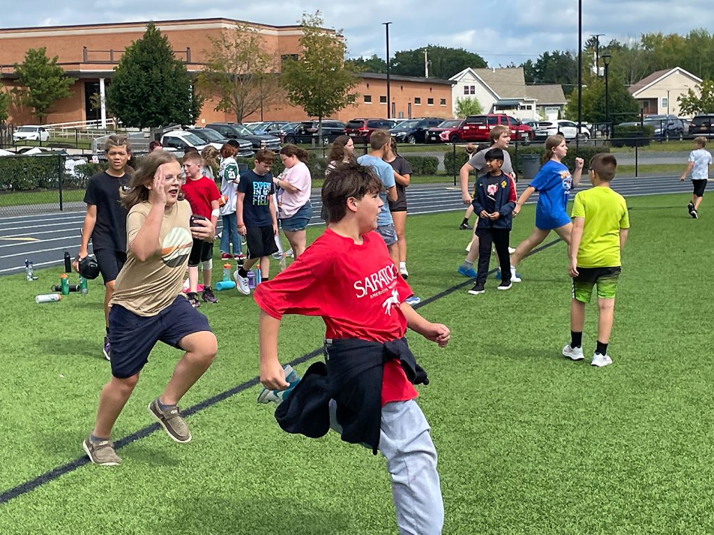 students running on the turf field.