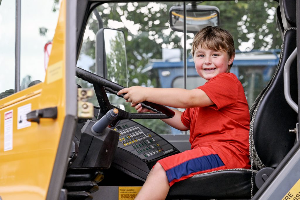 Little boy pretending to drive a bulldozer.