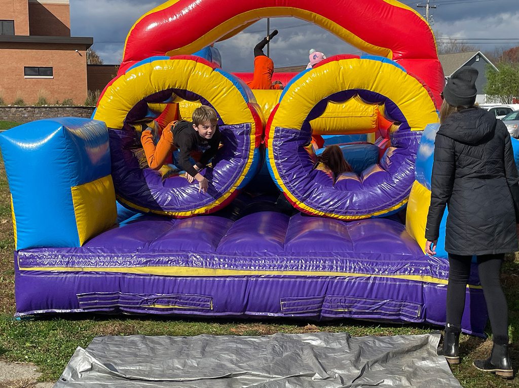 Elementary student crawling out of the bounce house.