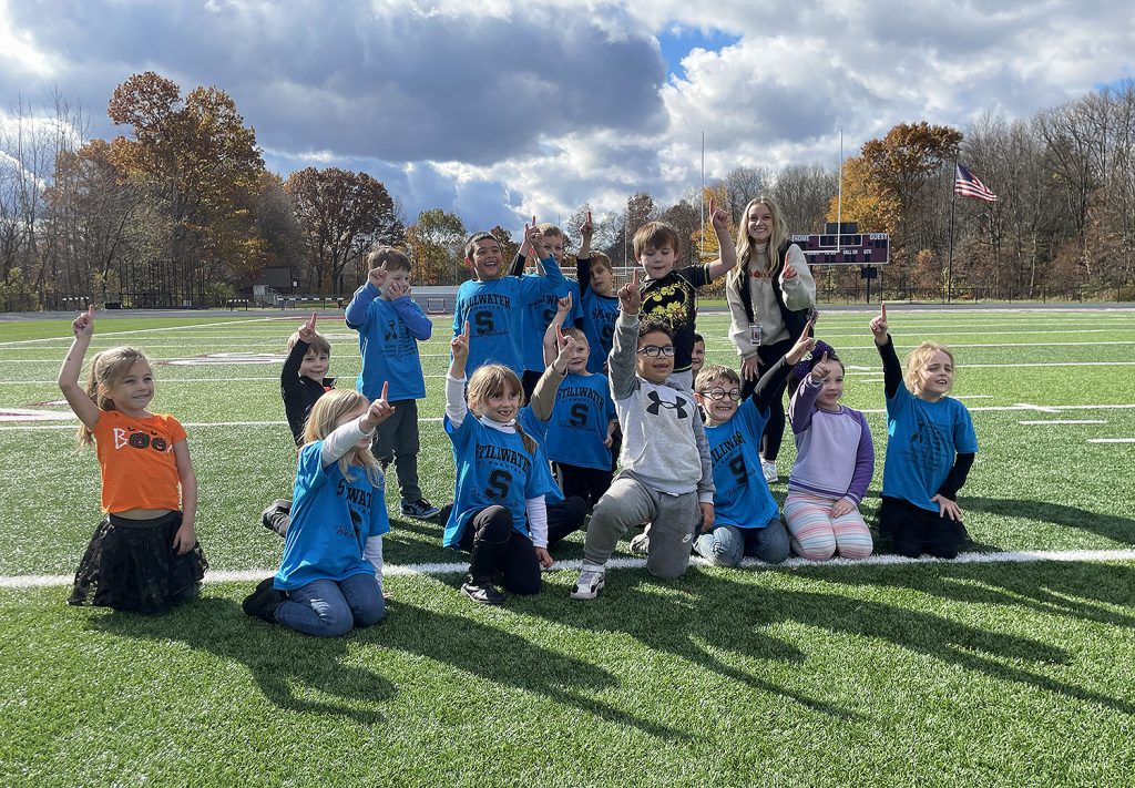 Group photo of elementary students doing the number "1" sign.