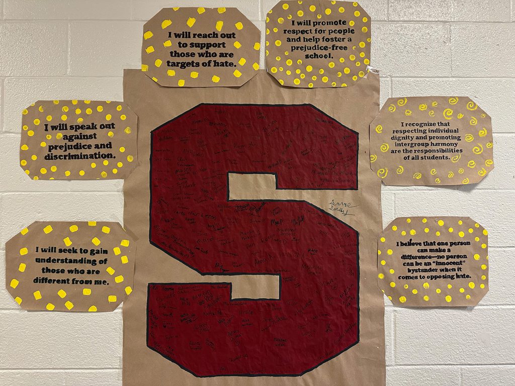 Giant red Stillwater "S" with student signatures with the "No Place for Hate" pledge statements surrounding it.