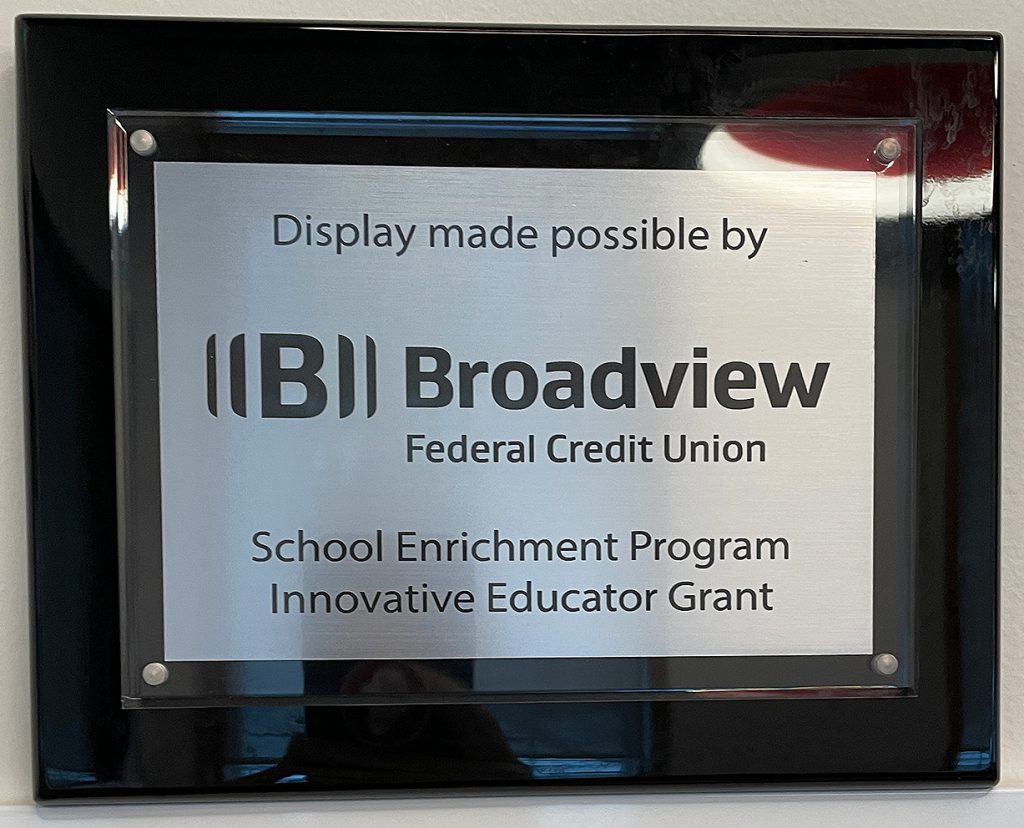 Plaque that reads "display made possible by Broadview Federal Credit Union." School Enrichment Program. Innovative Educator Grant.