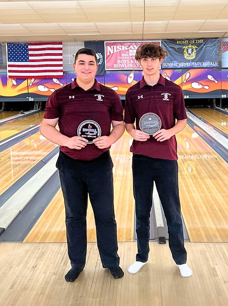 Two varsity bowling team members holding their medals.