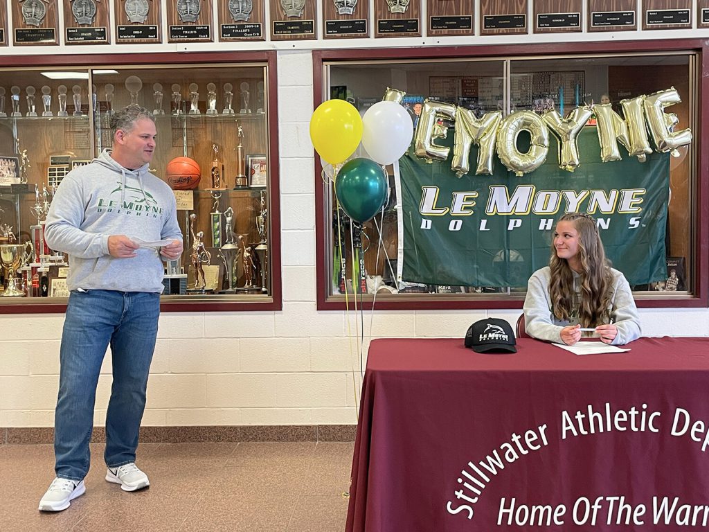 Father speaking as his daughter sits at a table to the right looking at him.