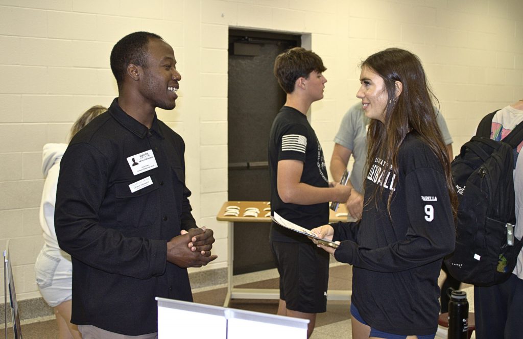 One student smiles in conversation with an adult.