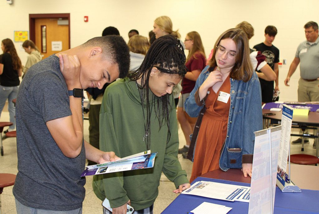 Two students looking invested and listening to some adult.
