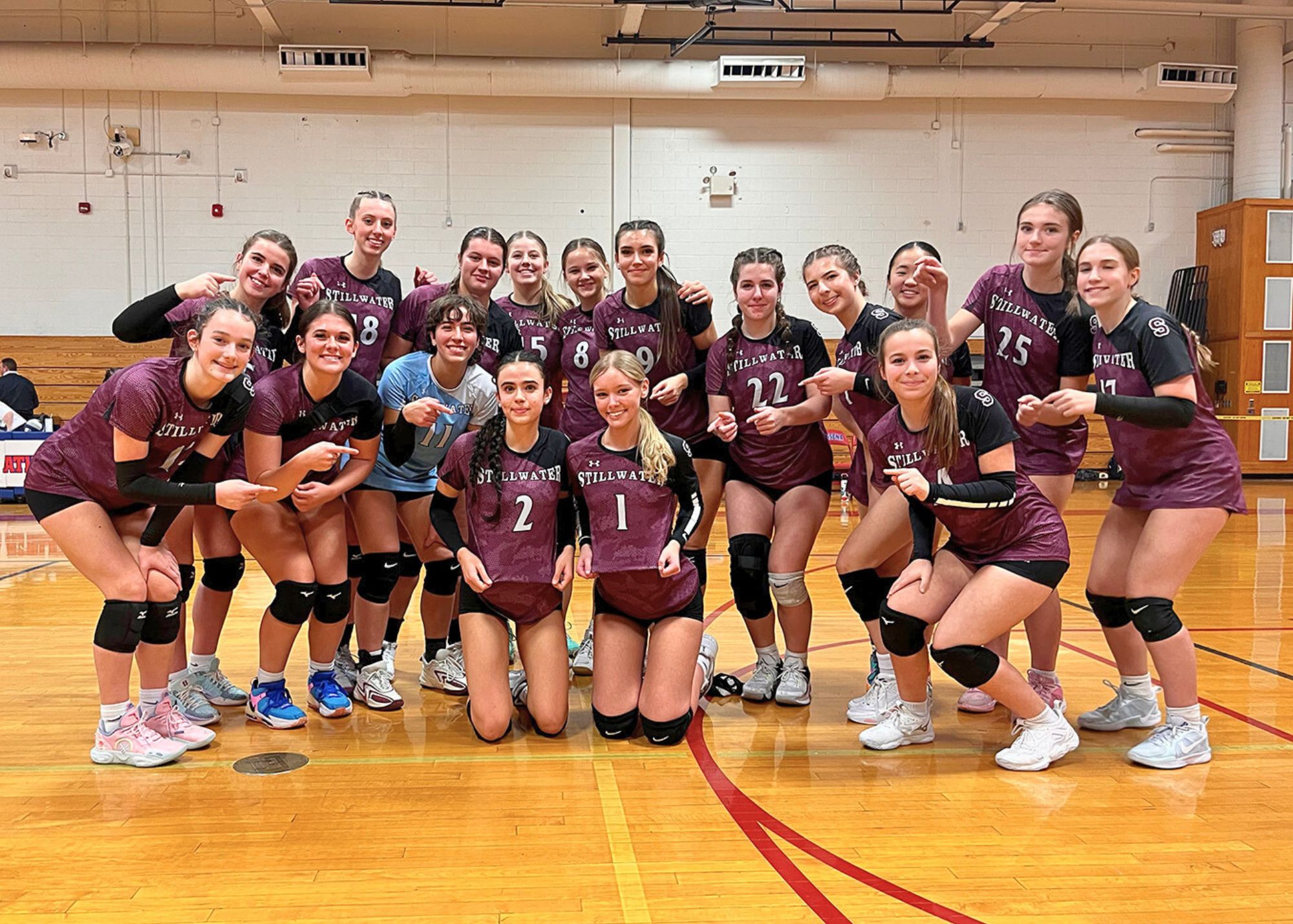 Athletes posing in their team shirts.
