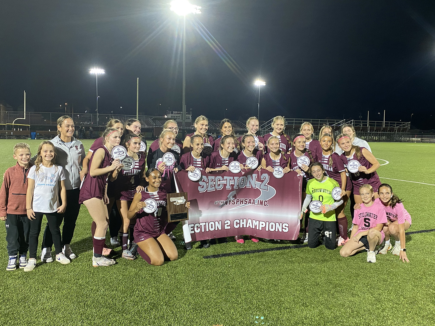 soccer team posing with banner that says sectional 2