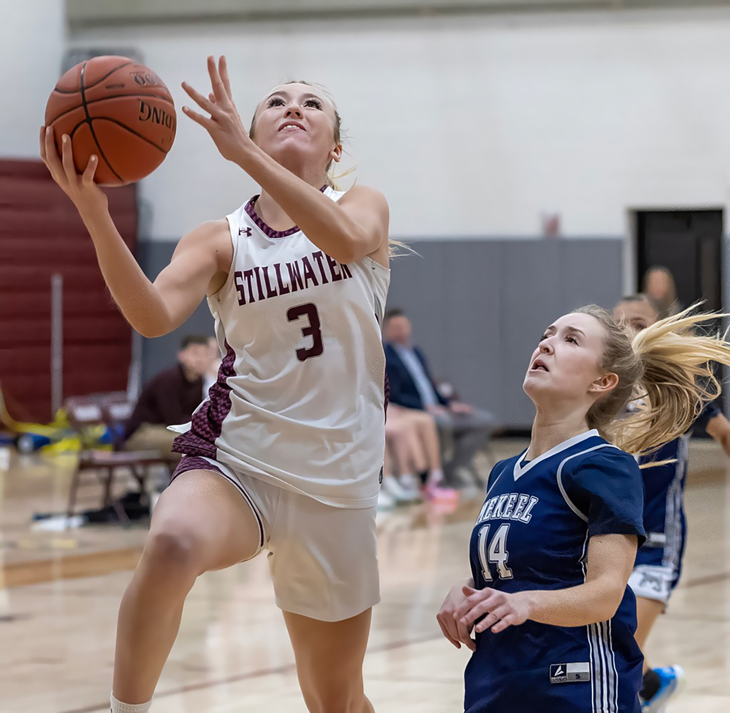 student with basketball with opposing team about to take ball as they score point