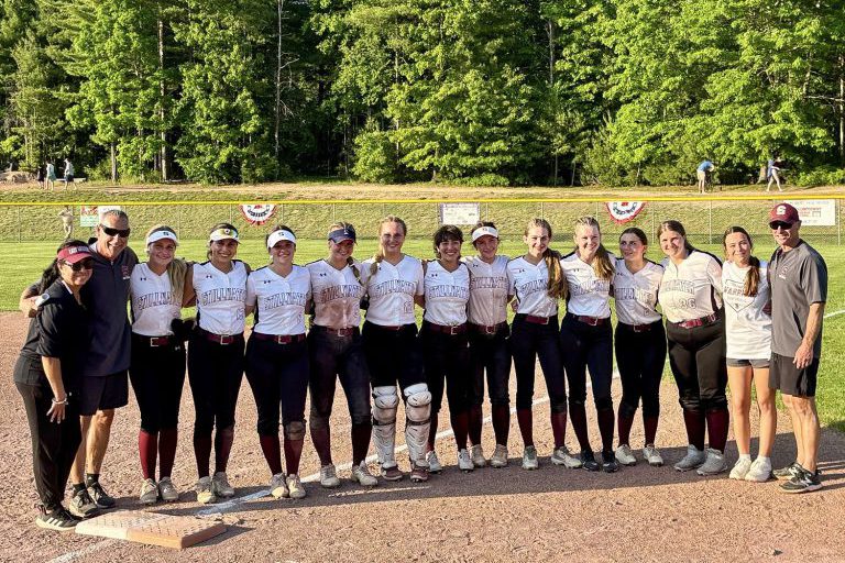 Girls varsity softball team poses in photo outside at field